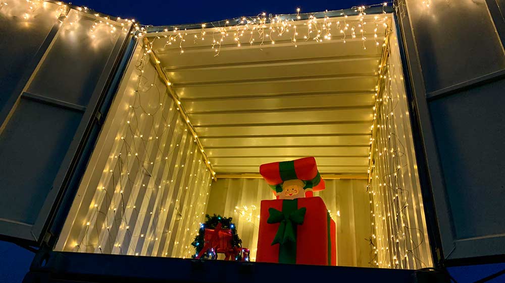 Aufwändige Weihnachtsdeko bei NIESEN – ein golden leuchtender Container und ein grüßender Weihnachtsmann